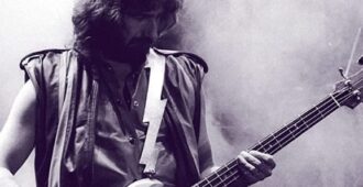 El bajista inglés Geezer Butler de la banda Black Sabbath tocando el bajo en escenario en parte de imagen de la portada de su autobiografía Into the Void: From Birth to Black Sabbath - and Beyond del año 2023