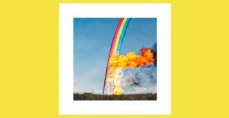 Imagen con bandera de arcoíris quemada en un campo con cielo azul de fondo en la portada del álbum estudio Átta de la banda islandesa de música Sigur Rós del año 2023