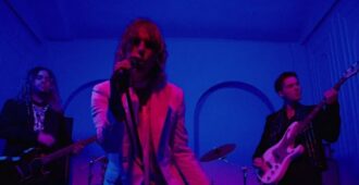 Integrantes de la banda británica The Struts en escenario tocando en el video musical de su sencillo Too Good At Raising Hell del año 2023