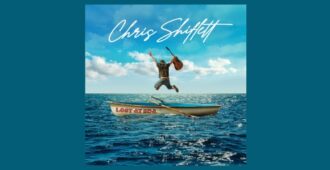 Hombre con guitarra en mano saltando en balsa en el mar azul en la portada del álbum de estudio Lost at Sea del guitarrista estadounidense Chris Shiflett del año 2023