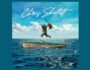 Hombre con guitarra en mano saltando en balsa en el mar azul en la portada del álbum de estudio Lost at Sea del guitarrista estadounidense Chris Shiflett del año 2023